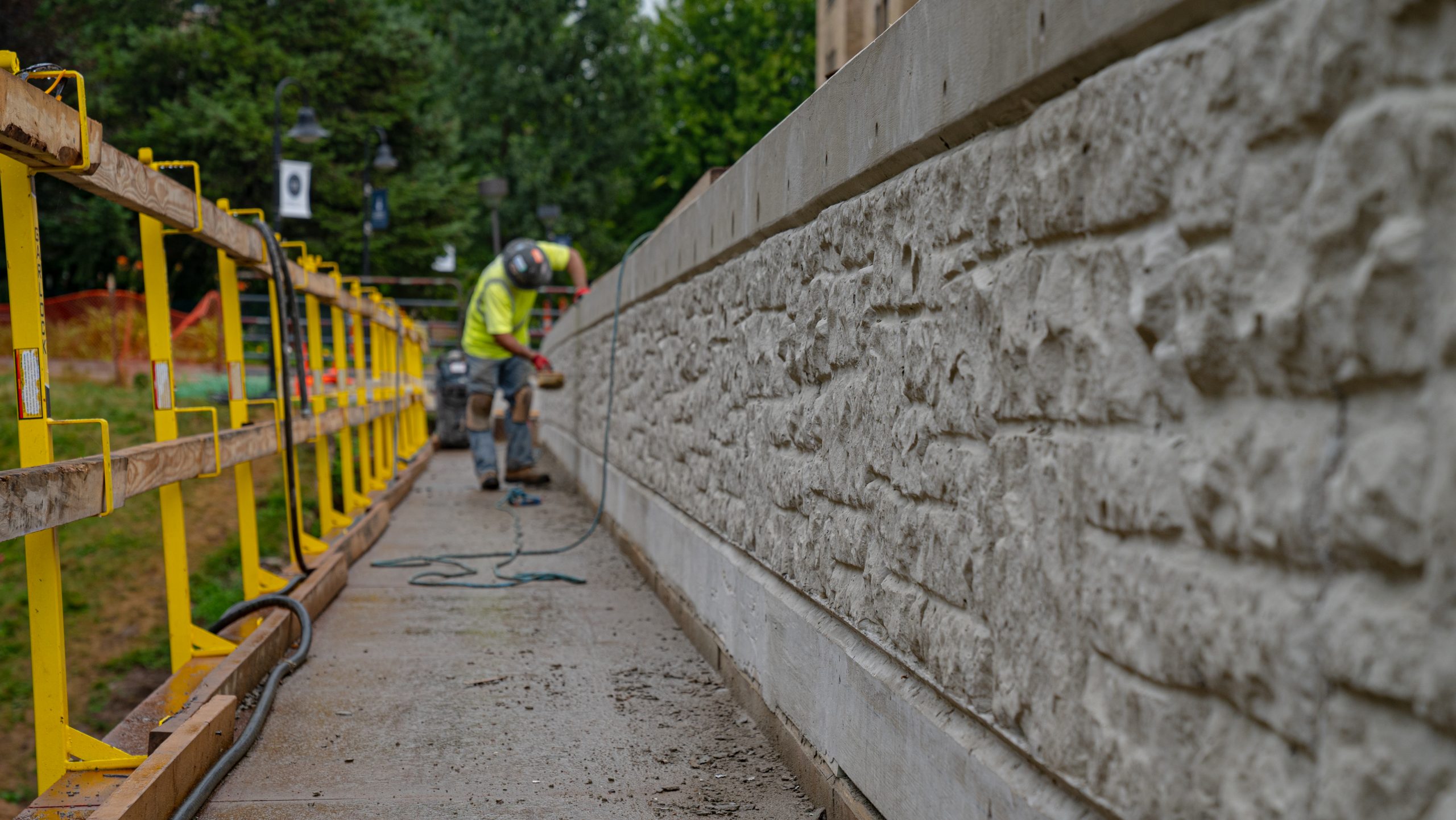 Worker adding texture to side of Lawrence University Pedestrian Bridge
