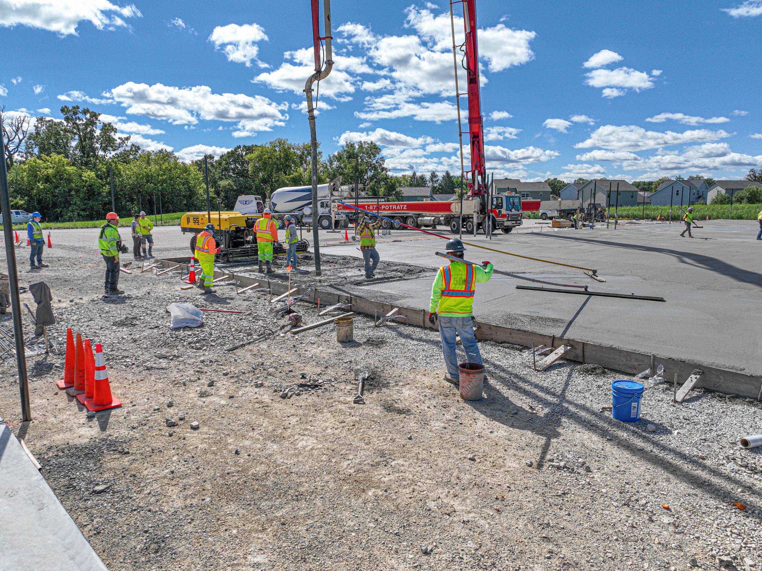 Ground view of group of worker leveling and pouring concrete on the Kettle Moraine Tennis Courts