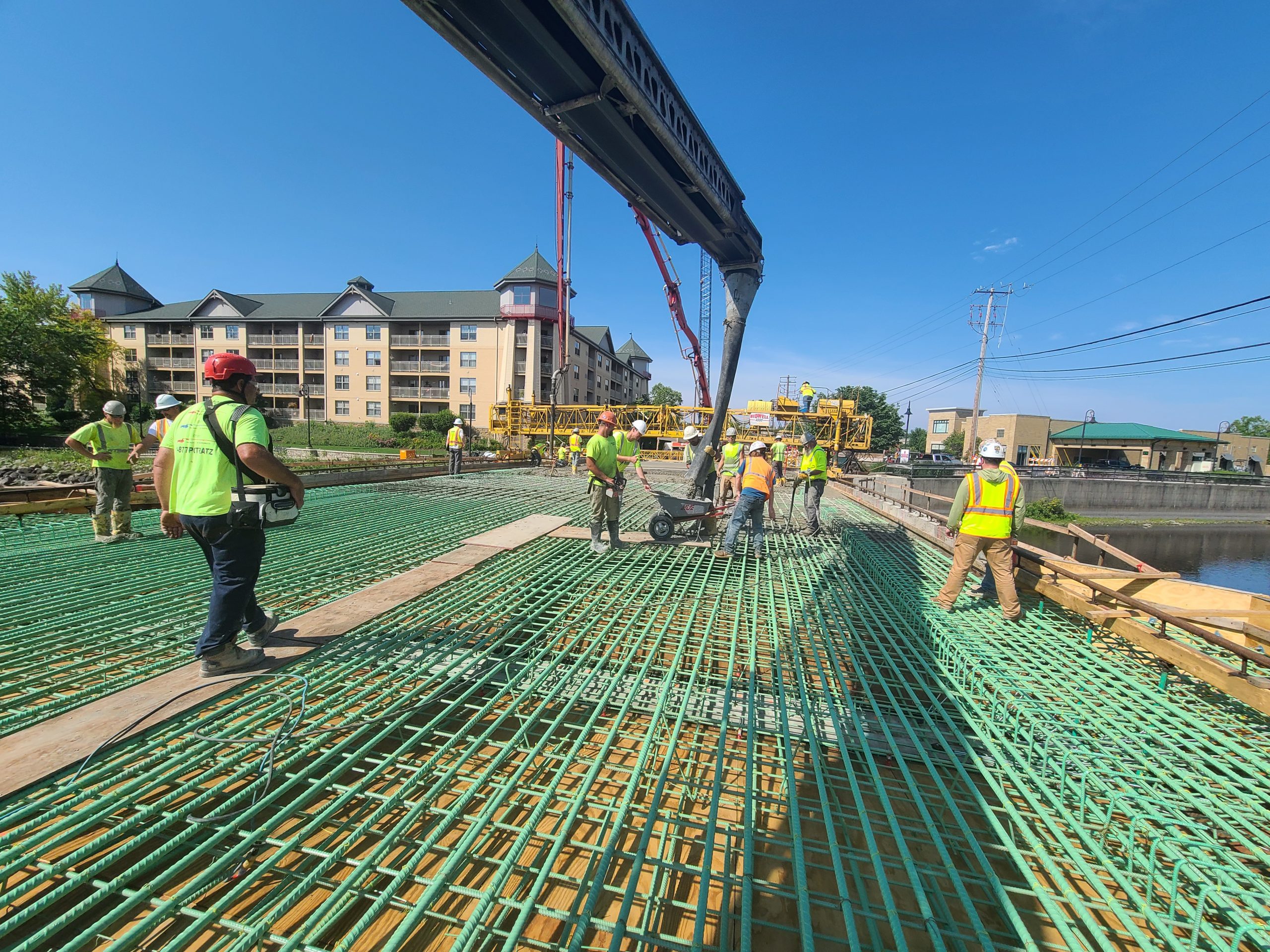 Wide shot of construction workers pouring concrete on Jefferson Street Bridge
