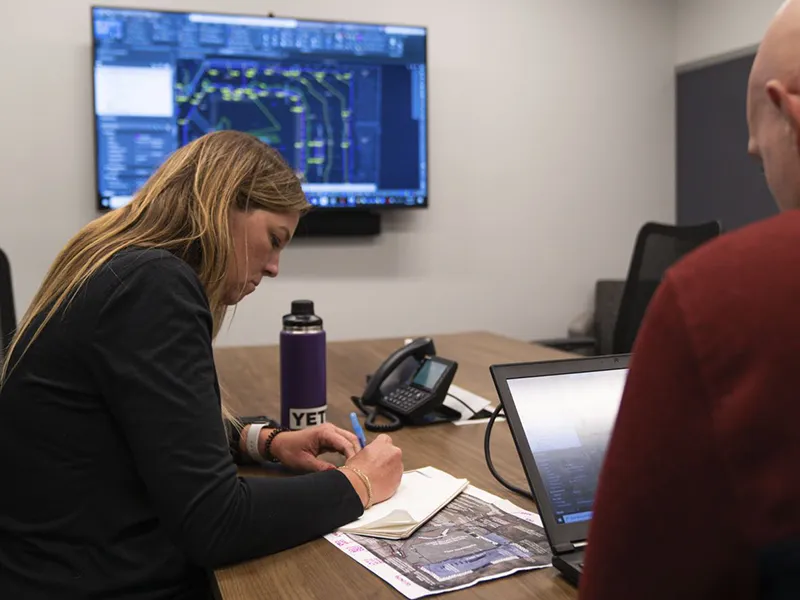 woman and man at desk with blueprints