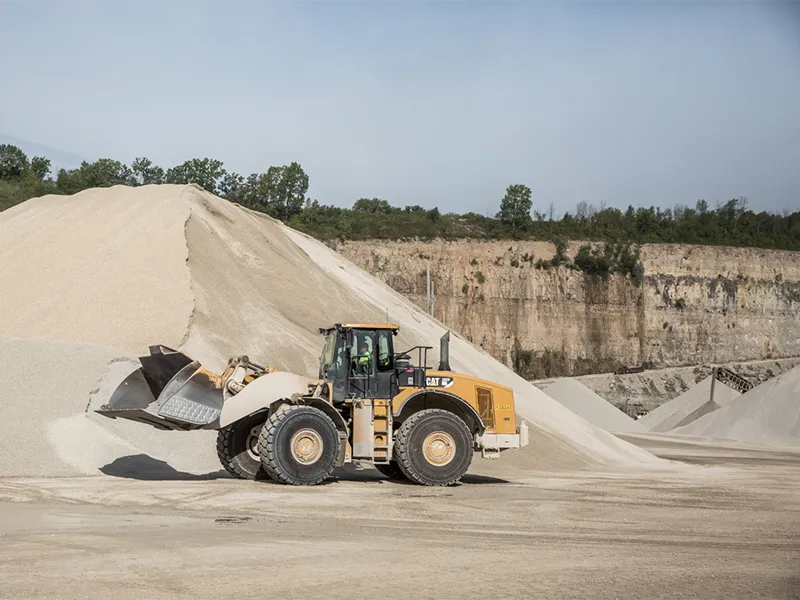 Skid loader moving sand