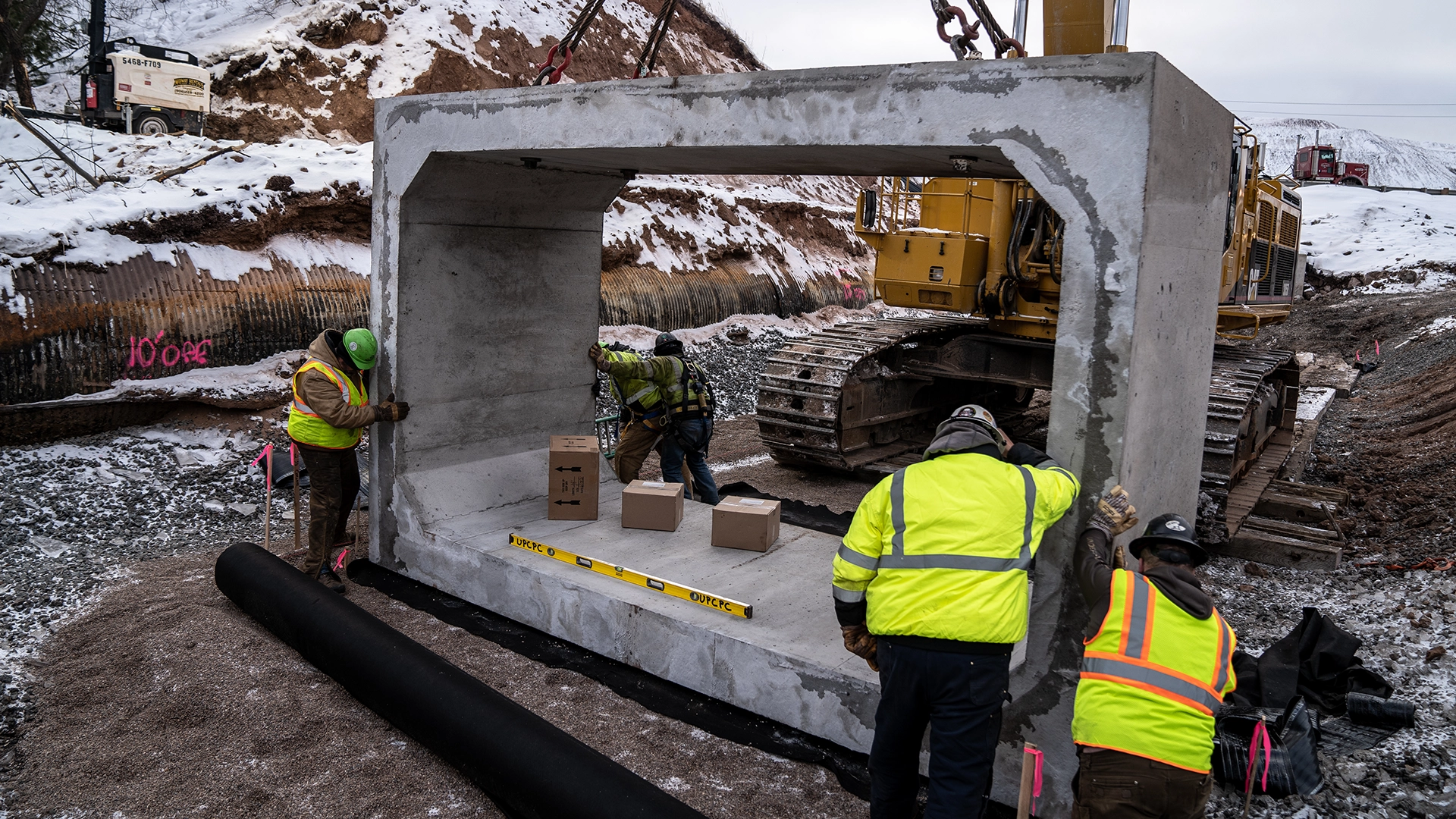 men moving empire mine box with crane