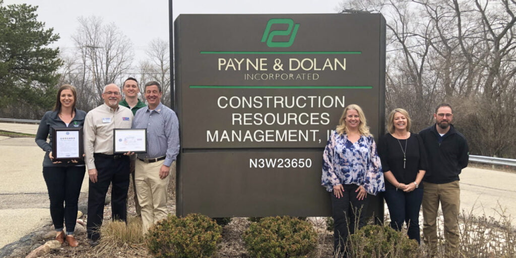 employees standing in front of payne & dolan sign