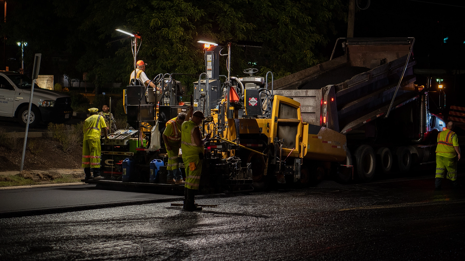 construction workers with heavy equipment at night