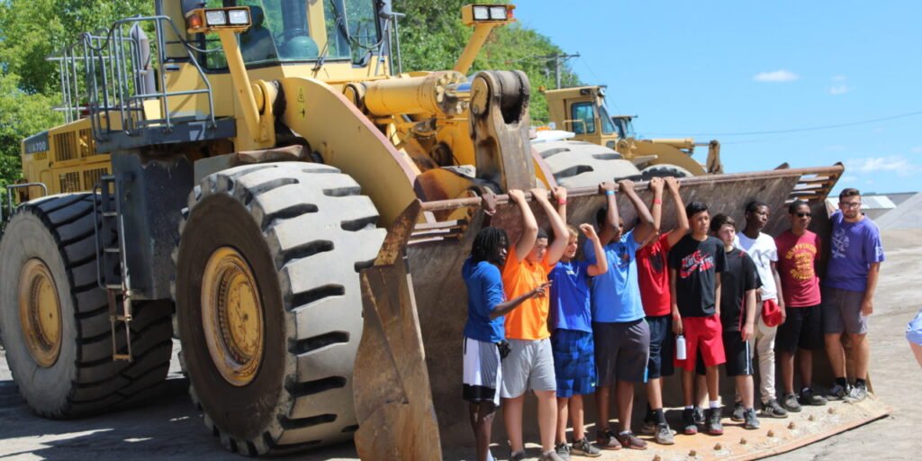 children standing in construction equipment