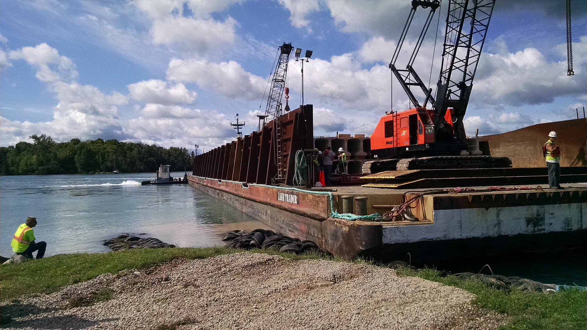crane on barge with construction workers