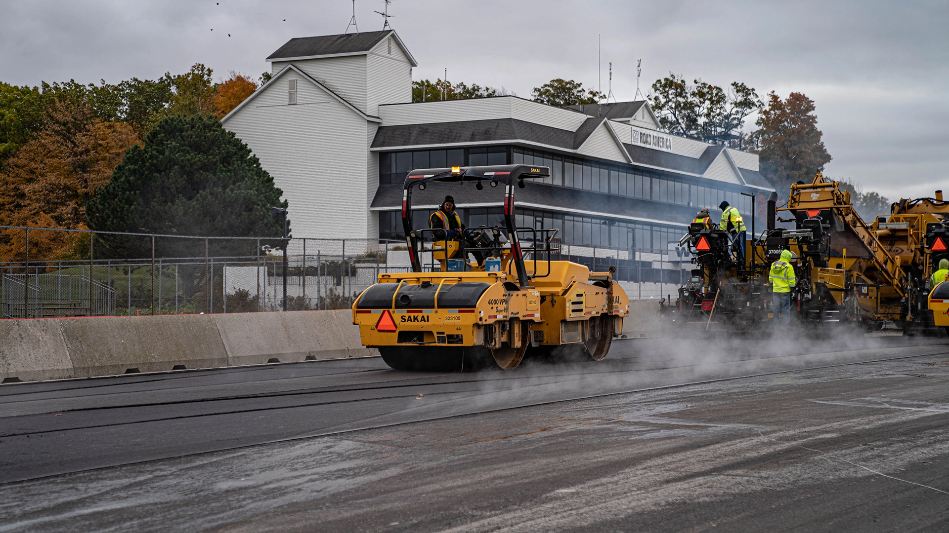 steamroller and construction workers paving road