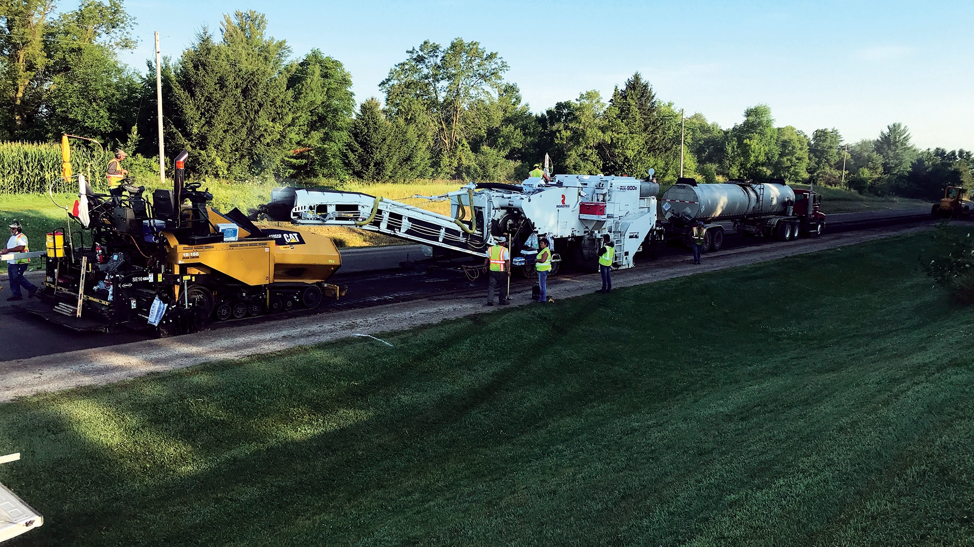men with heavy equipment on side of road