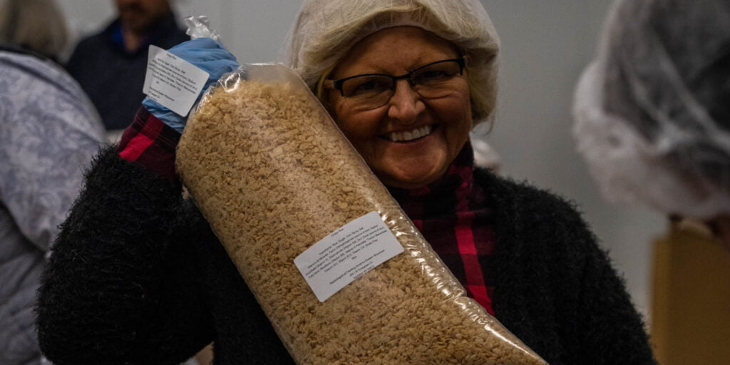 woman smiling with bag of cereal