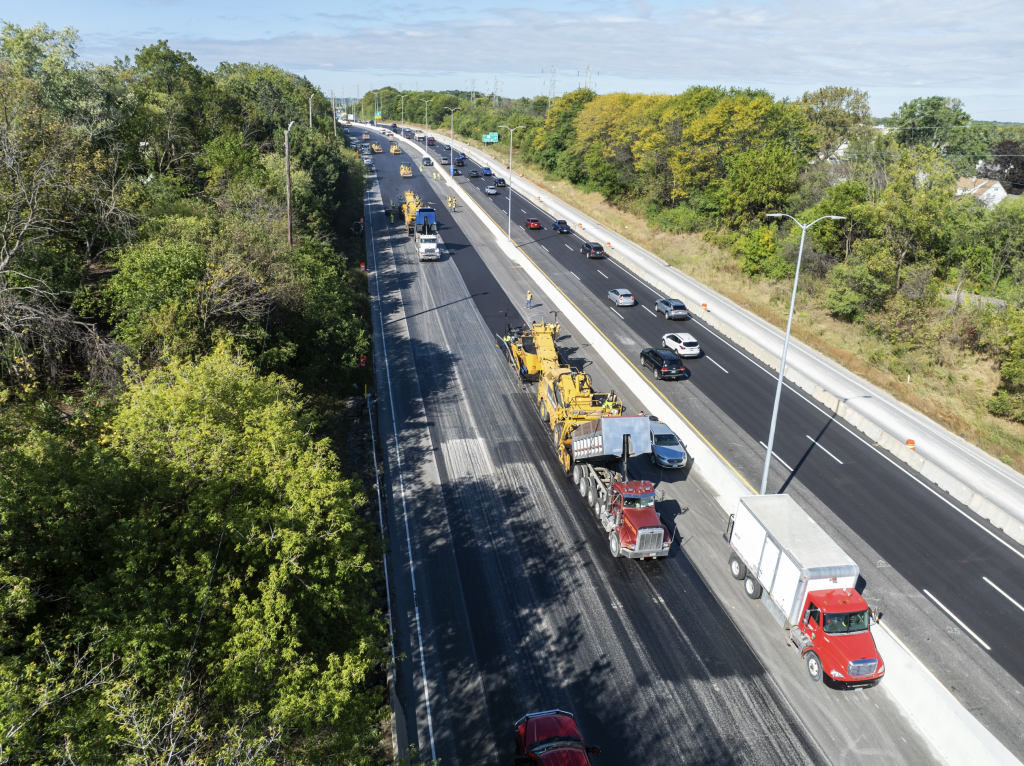 Aerial view of heavy machinery applying asphalt over I894