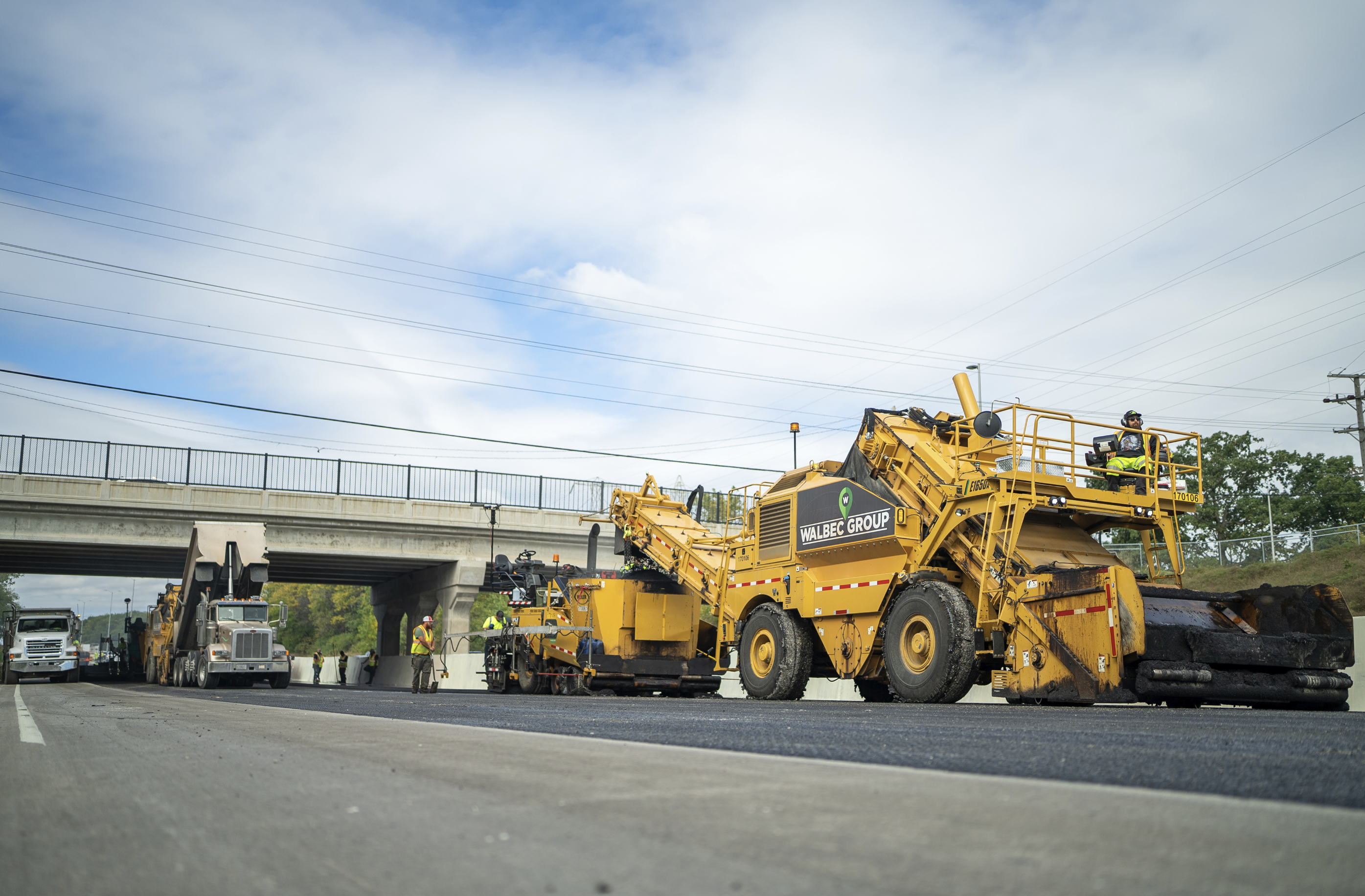 Ground view of Walbec heavy machinery applying hot mix asphalt to I894