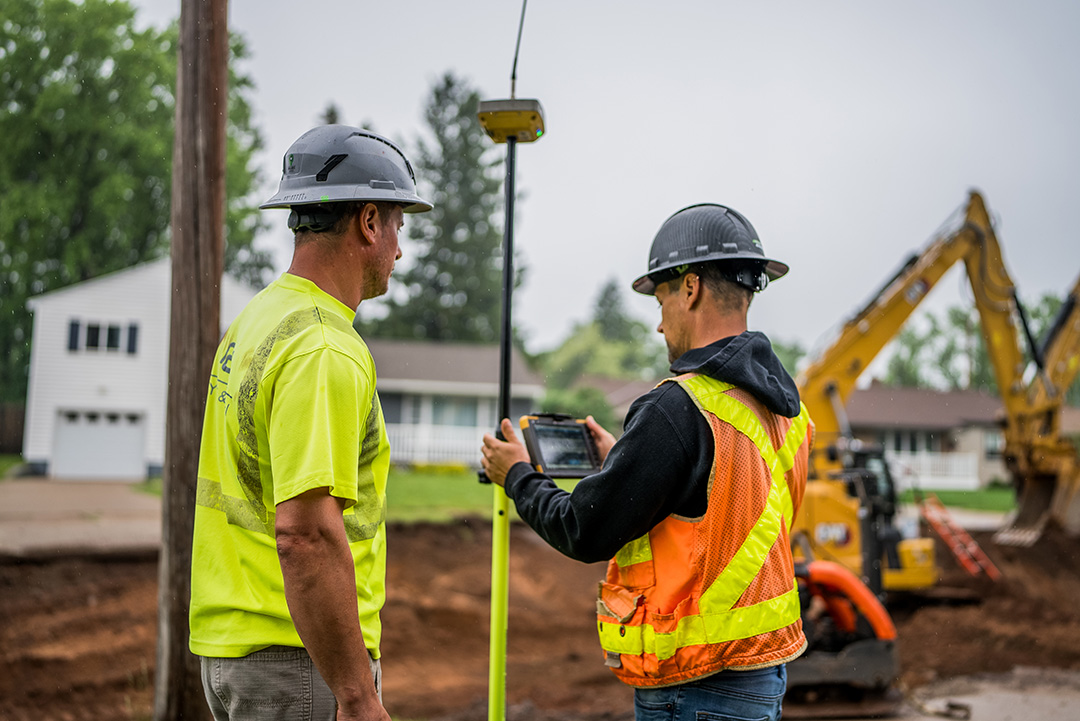 Close up of two construction workers with the construction the background for the City of Ishpeming, MI